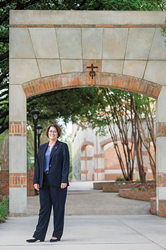 Dekaani Patricia Roberts seisoo Pyhän Marian kaarevan portin edessä