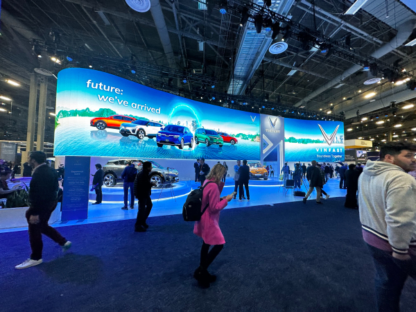 דוכן VinFast ב-CES 2023, עם כלי רכב המוצגים ברקע והמשתתפים בחזית