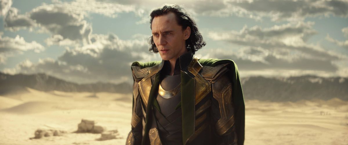 لوکی (تام هیدلستون) در صحنه ای از فصل اول Loki در یک صحرا ایستاده است