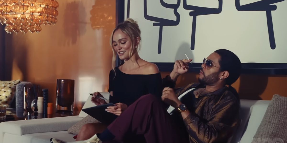 The Weeknd در حالی که در کنار لیلی رز دپ روی یک کاناپه در The Idol نشسته سیگار می کشد.
