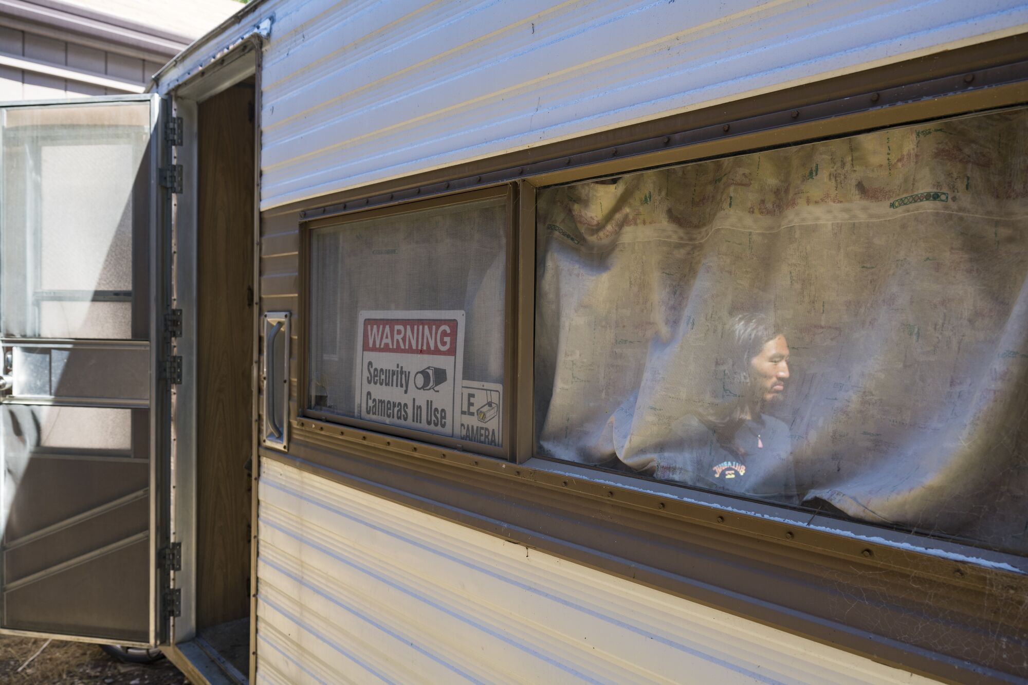 A man reflected in the window of a trailer
