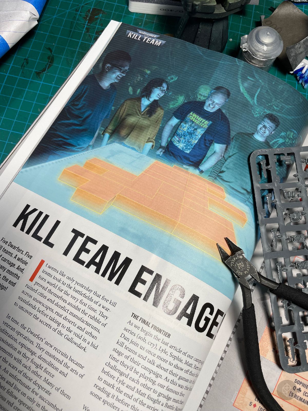 A page from White Dwarf showing a group of players around a virtual Kill Team map.