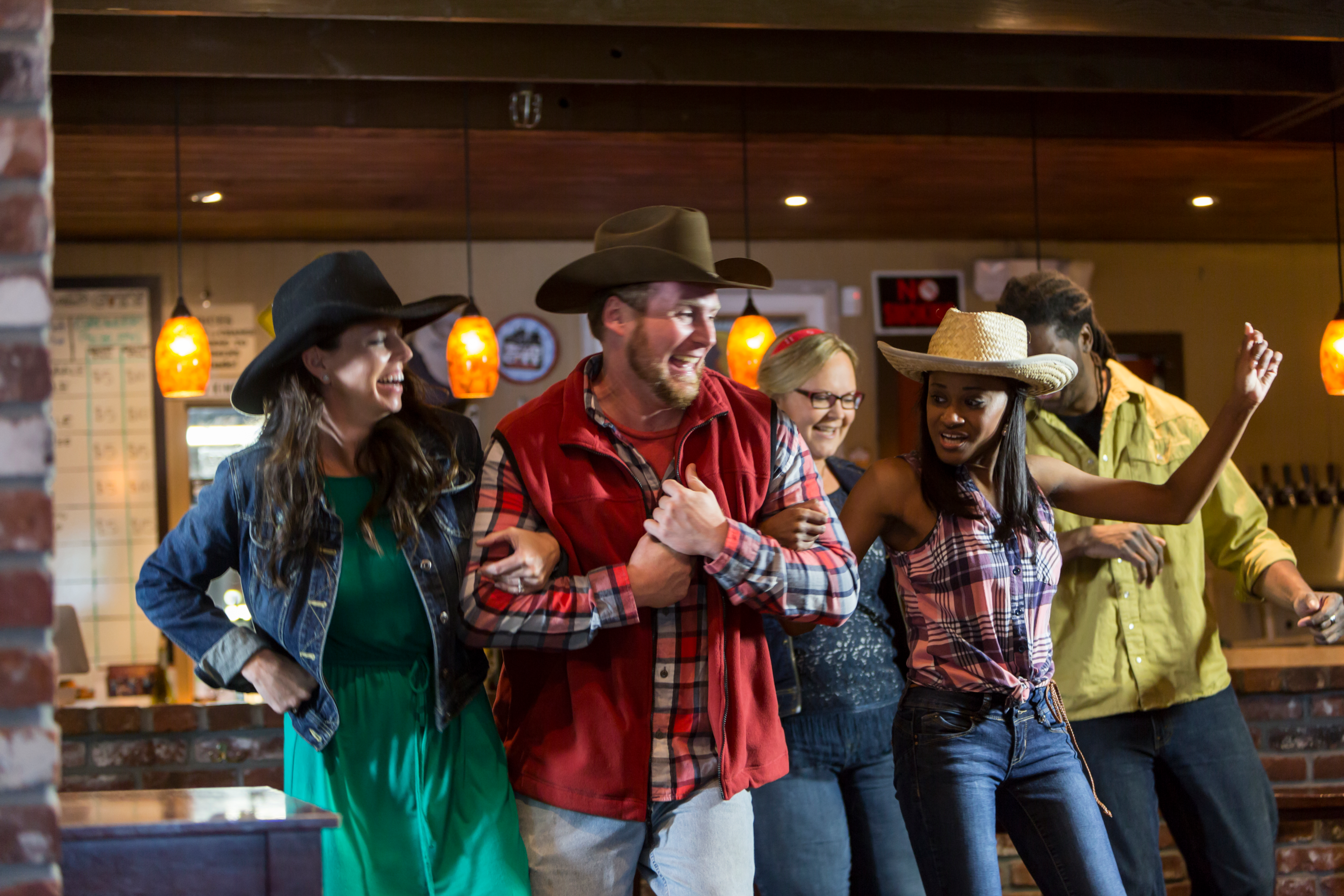En gruppe venner, der danser og hygger sig i en countrybar