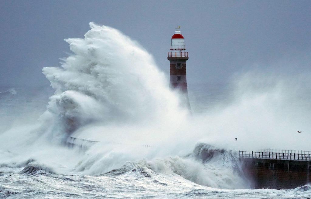 Ogromne fale rozbijają się o ścianę morską i latarnię morską Roker w Sunderland na końcu burzy Arwen, 27 listopada 2021 r.