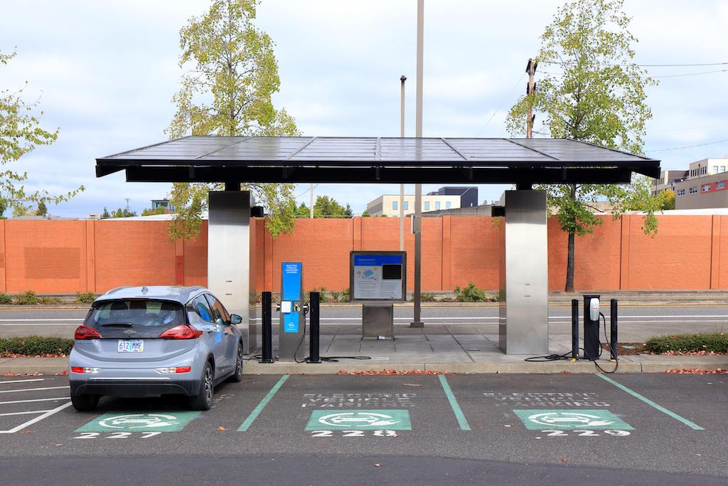 A solar canopy electric vehicle charging station with ebike battery charging lockers.