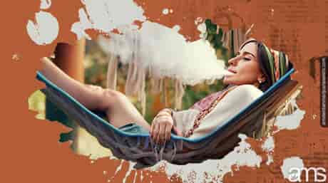 A hippie girl smoking in a hammock.