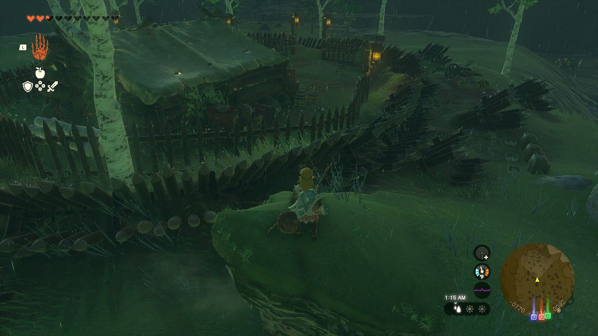 Link stands on a small cliff and prepares himself to jump over the spiked fence in Zelda: Tears of the Kingdom
