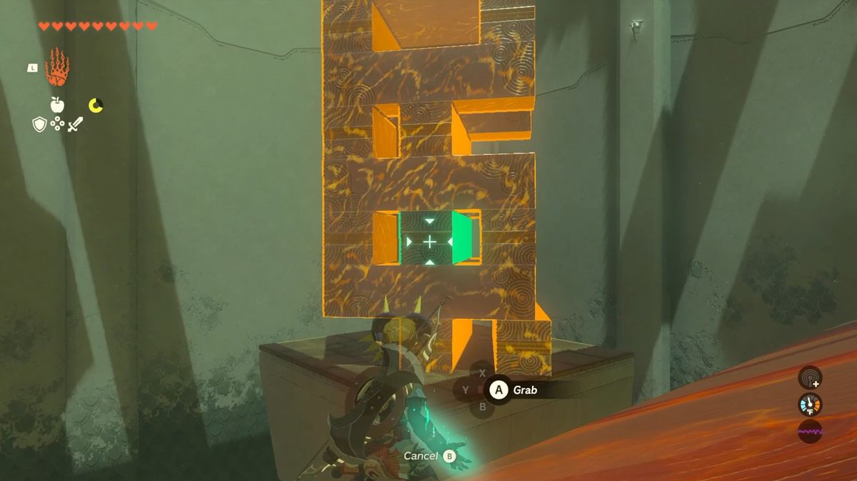 Link highlights a tower of blocks with his Ultrahand ability in Zelda: Tears of the Kingdom. The block on the third row center is glowing green, while the rest are orange.