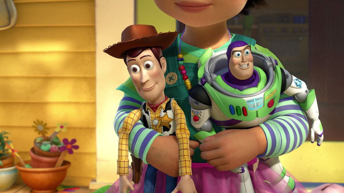 A small child, Bonnie, holds Woody (a cowboy action figure) and Buzz (a space ranger action figure)