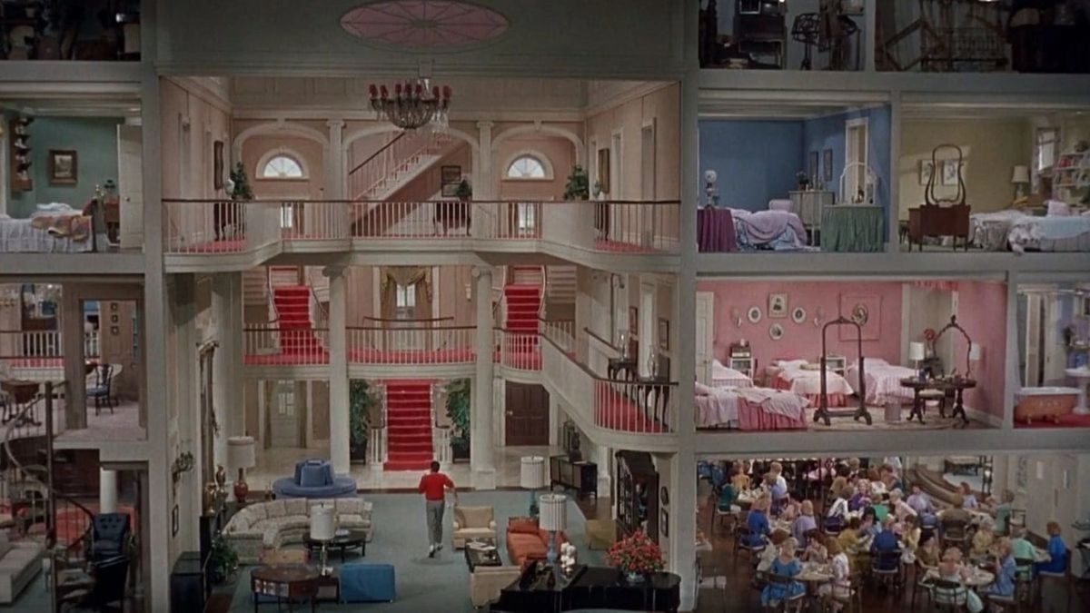 A wide-shot of a man walking into a house where every floor is visible in The Lady’s Man.