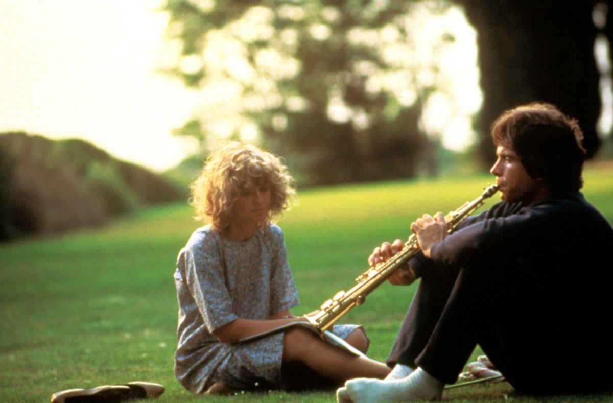 Warren Beatty playing a flute beside a woman in a field in Heaven Can Wait.