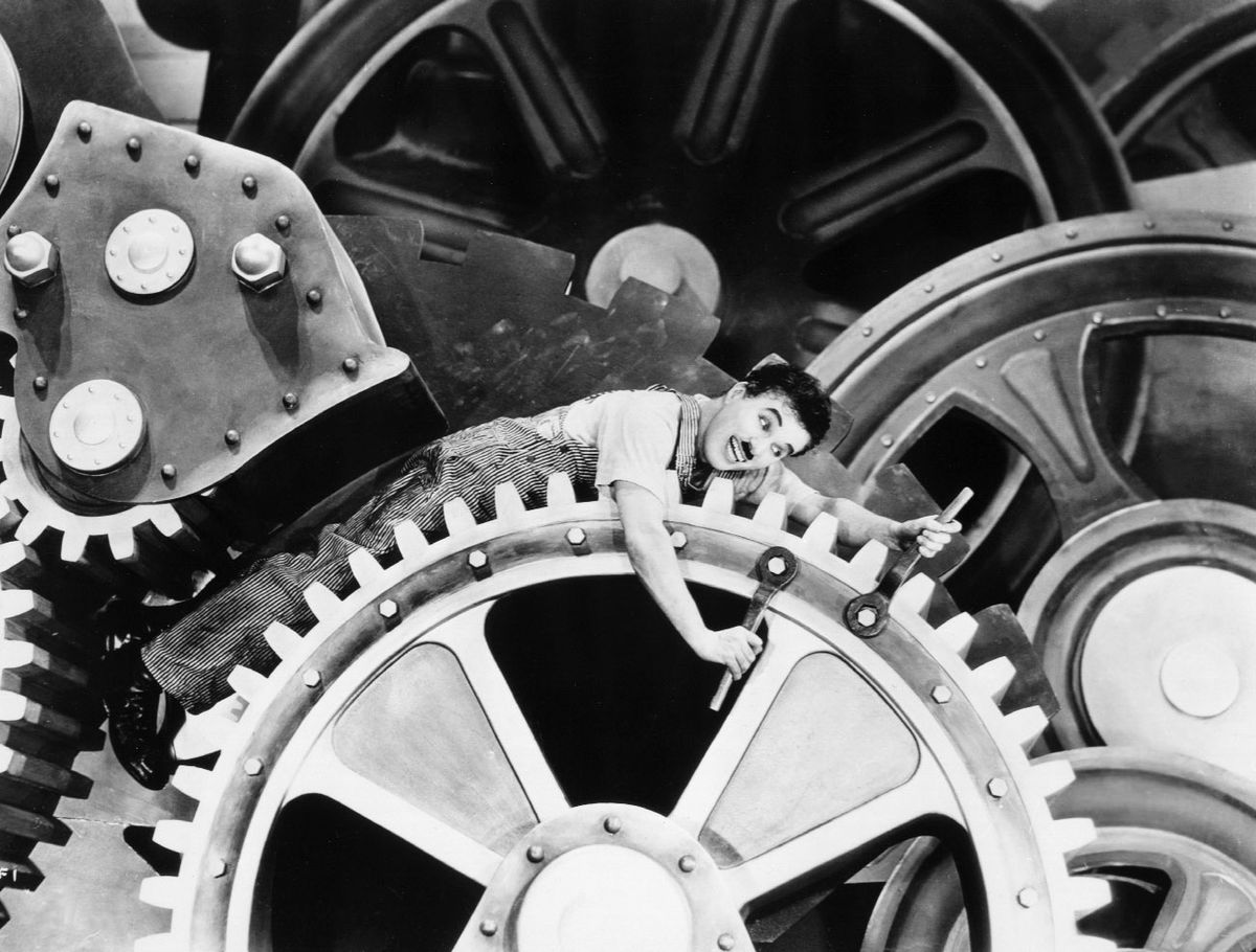 Charlie Chaplin trapped in the gears of a machine in Modern Times.