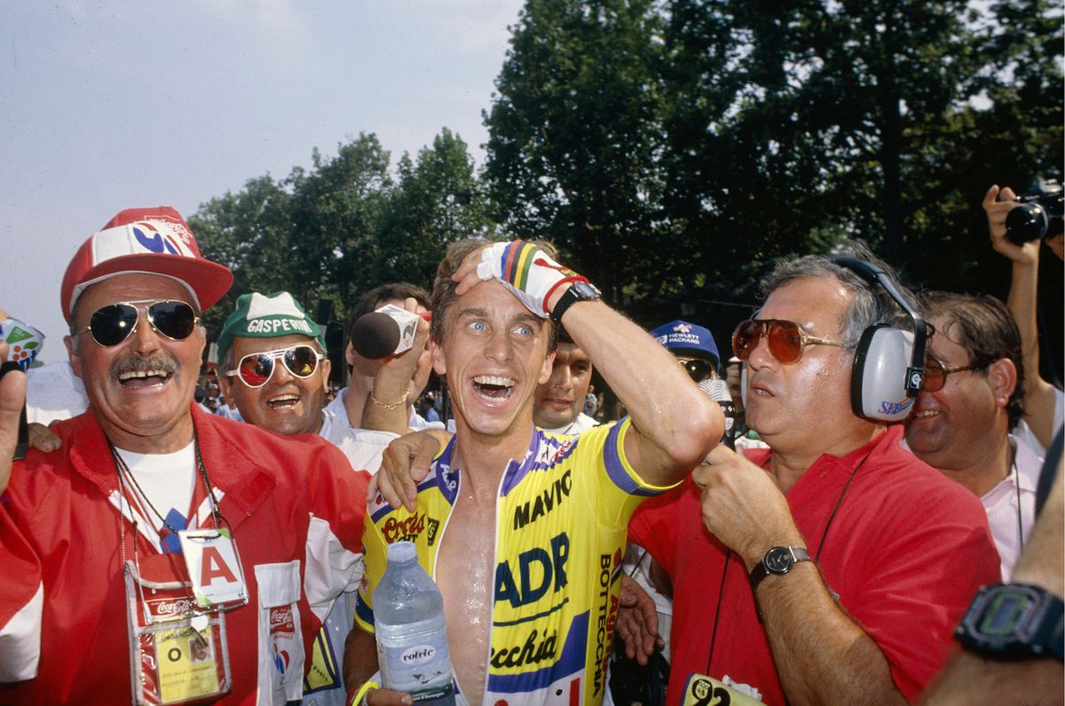 Greg LeMond holds his hand to his face in disbelief as he is congratulated after a miraculous Tour de France victory.