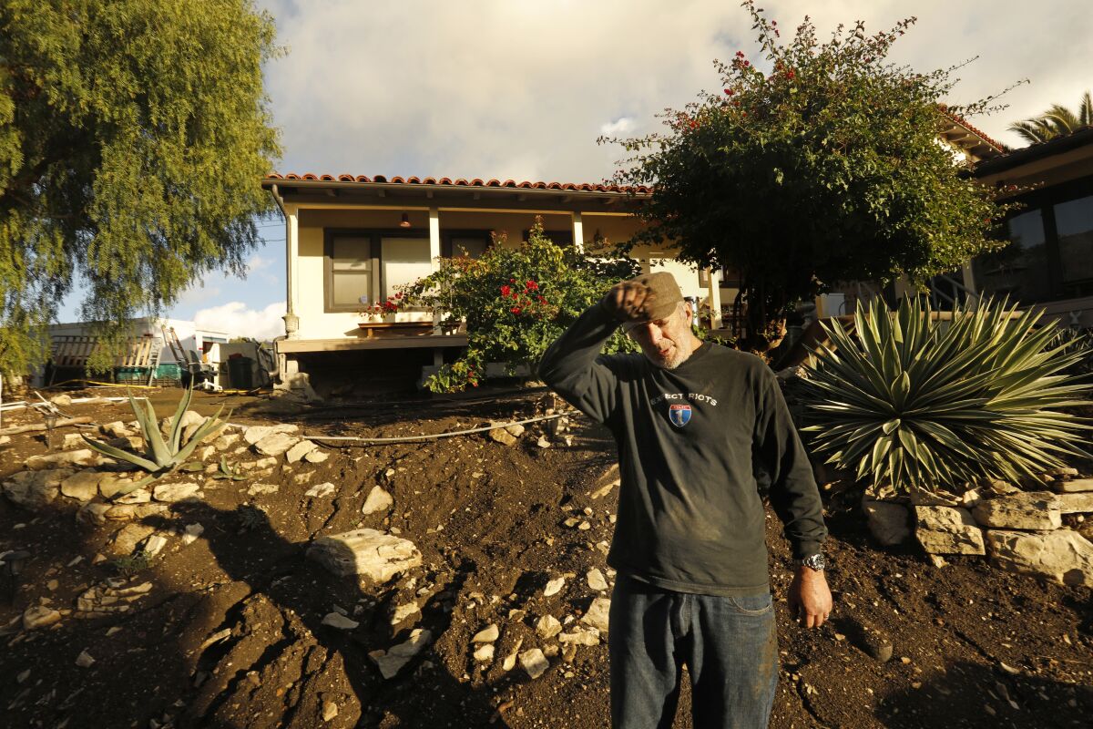 A man stands in front of his house with a shifting foundation