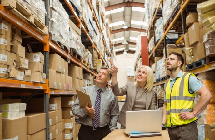 Warehouse manager and employee assessing inventory accuracy