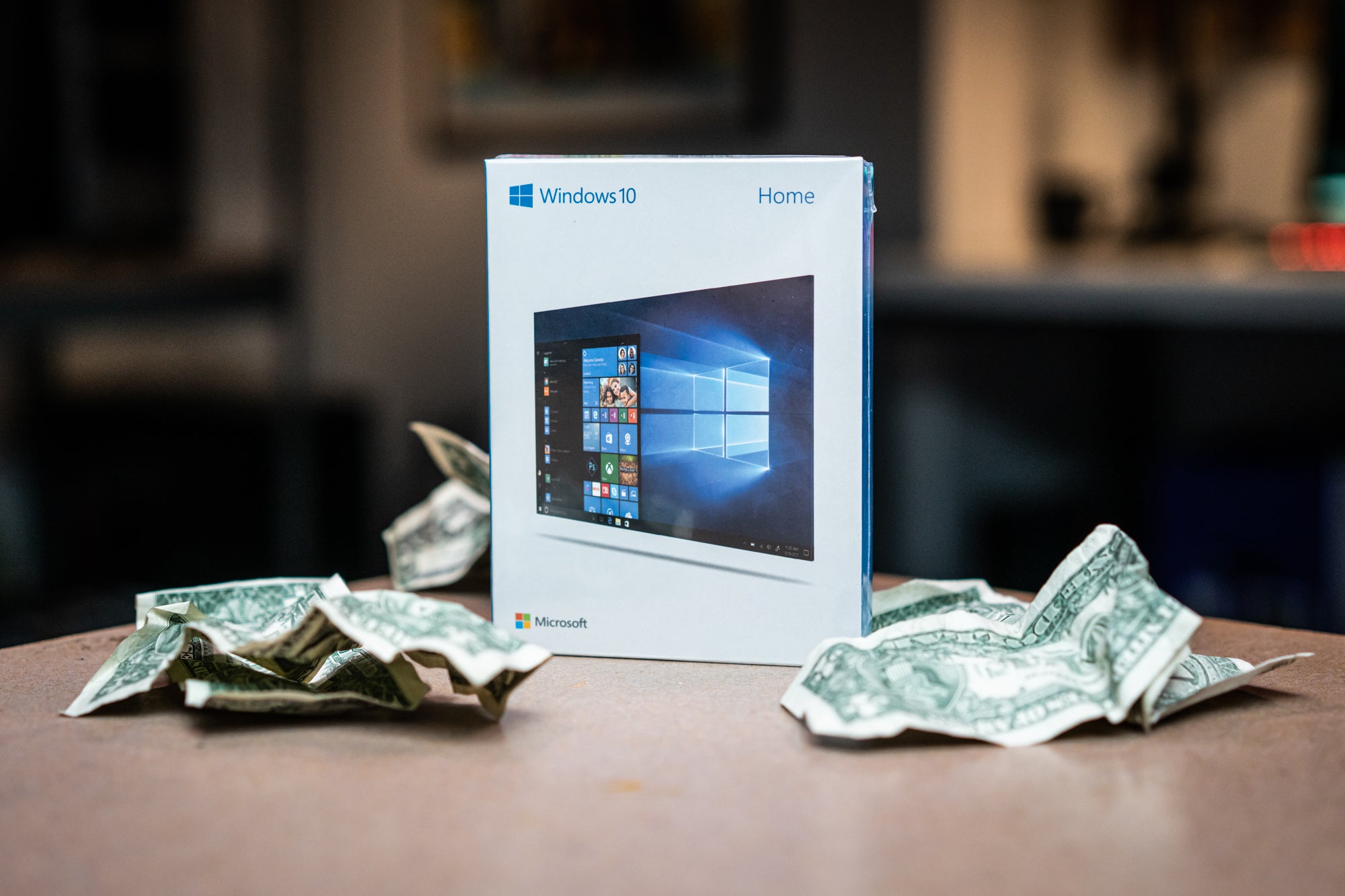Windows 10 boxed on table with crumpled money