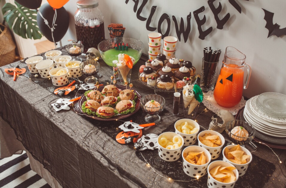 Food table filled with different type of food and drinks ready for Halloween party