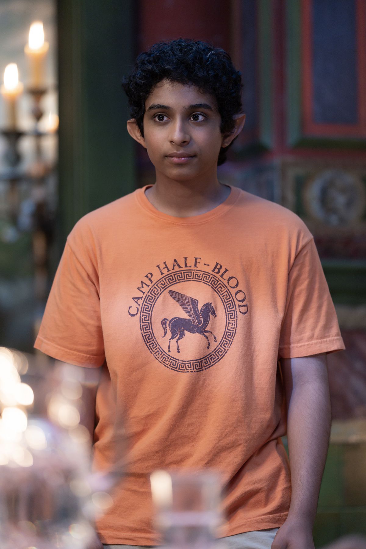 Grover (ARYAN SIMHADRI) in a Camp Half-Blood shirt