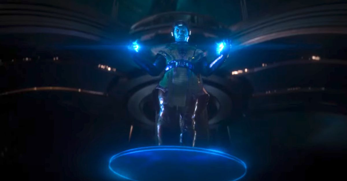 Kang appears hovering on a platform in green and purple armor with his hands glowing and a mask projecting a blue screen over his face in the trailer for Ant-Man and the Wasp: Quantumania