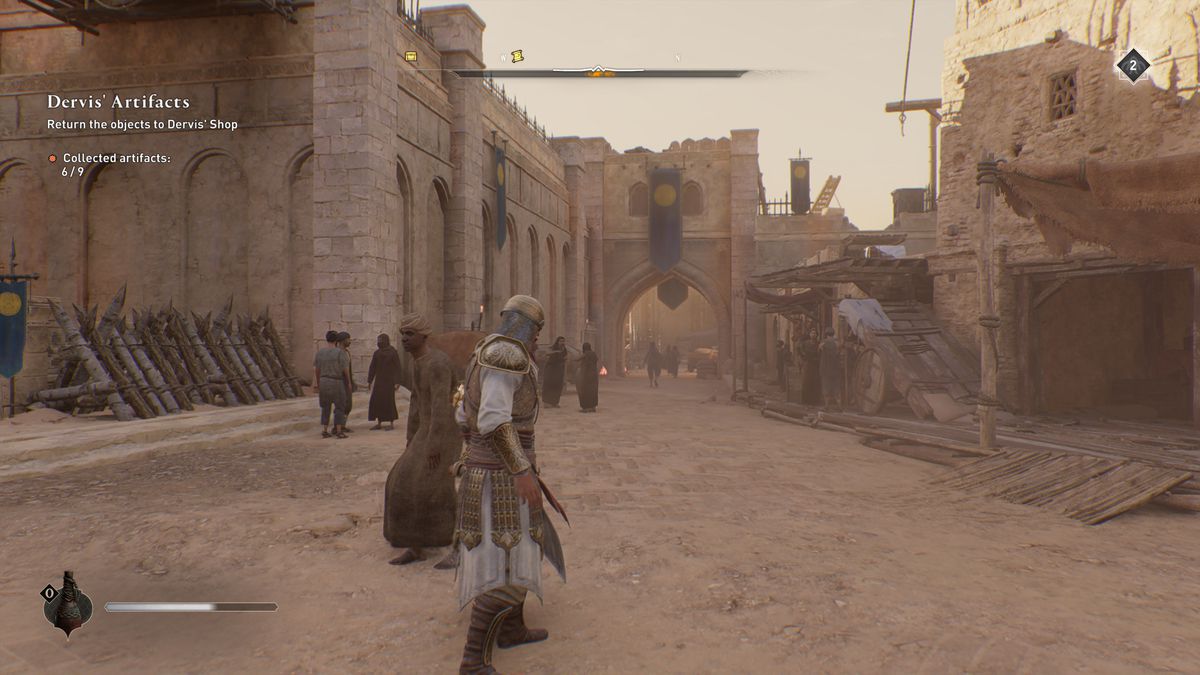 Basim stands by a castle with a hole in the wall while looking for Gear Chest in AC Mirage.