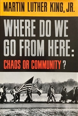 Cover of Martin Luther King Jr.'s "Where do we go from here" with a picture of people marching with a US flag. 