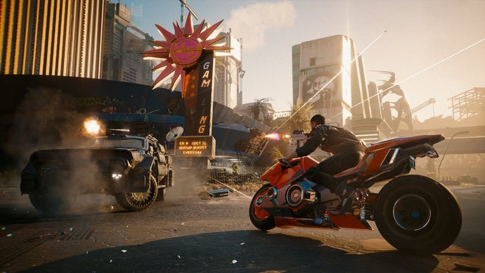 Cyberpunk 2077'nin Phantom Liberty genişletmesinden, kırmızı bir motosiklet üzerinde şehrin sokaklarında yarışan oyuncuyu, zırhlı bir araç ileride ateş açarken gösteren bir ekran görüntüsü.