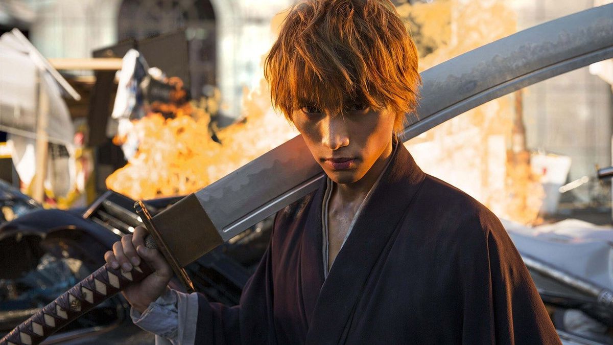 Sota Fukushi Ichigo Kurosakina pitelemässä suurta miekkaa tulen edessä Bleachissa.