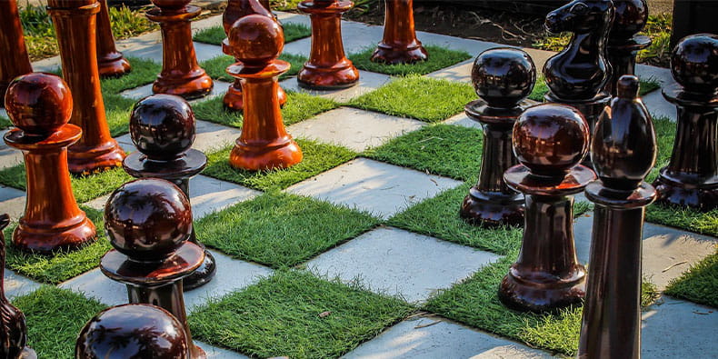 Sjakkbrikker på gressdekket spillebrett