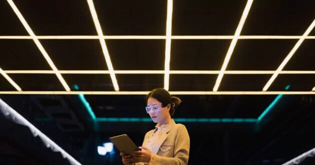 밤에 태블릿을 사용하여 증강 현실 안경을 쓴 젊은 사업가