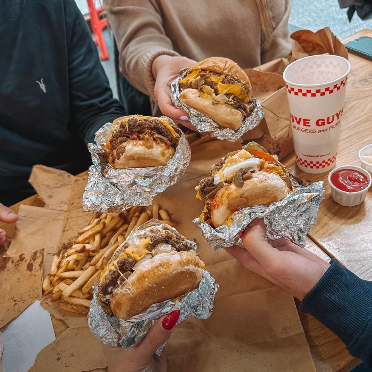 group of people eating burgers at a Five Guys fundraiser