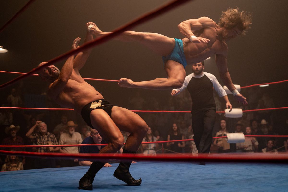 A wrestler diving at another wrestler in a ring.