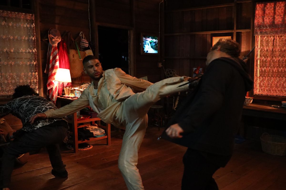 Nassim Lyes executes a sick side kick while wearing a white suit in a house in Mayhem!