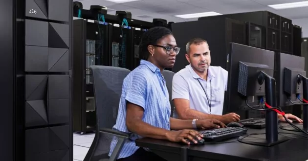 Team af to ingeniører, der arbejder på computer i serverrum med IBM z16