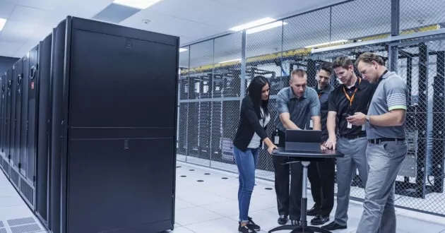 Team around a laptop in a data center