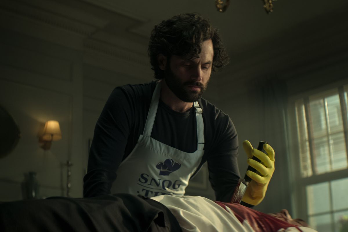 Penn Badgley as Joe Goldberg&nbsp;removing a knife from a dead man’s chest in You season four.