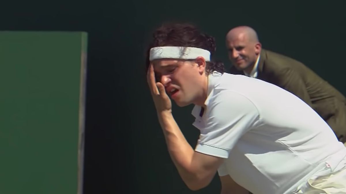 Kit Harington wipes sweat from his face with a pained expression, wearing tennis gear in 7 Days in Hell