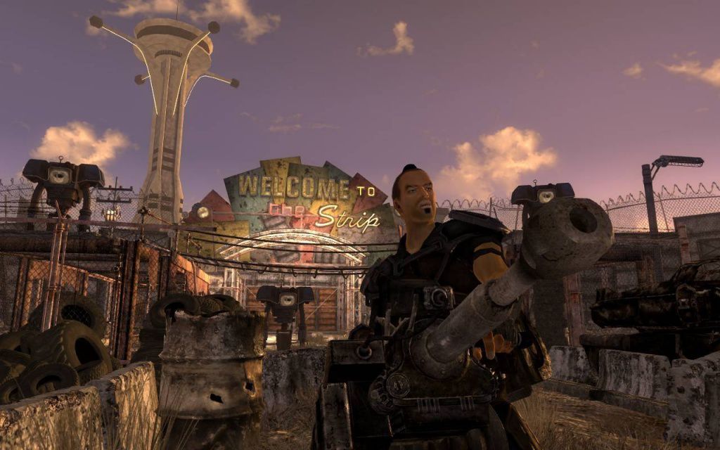 A Fallout: New Vegas screenshot of a guy with a gun in front of a sign that says “Welcome to the Strip” 