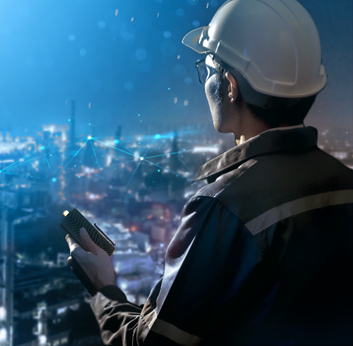 A worker with an electronic device in hand, overlooking a city