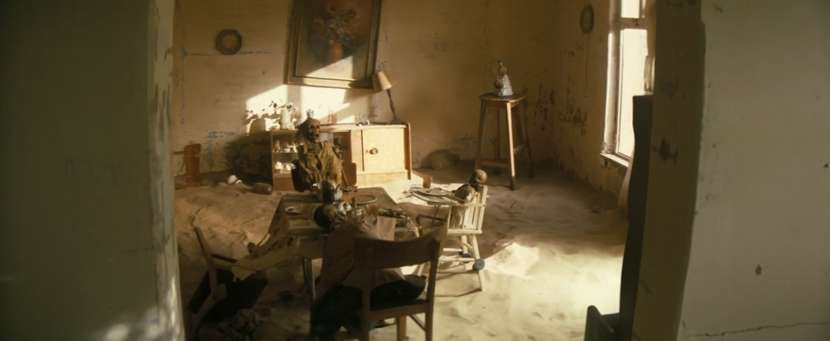 A shot of skeletons sitting at the dinner table in a deserted desert house from Fallout season 1 episode 2