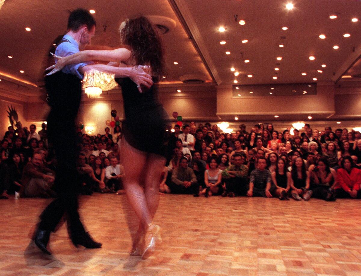 Dancers perform before a crowd.