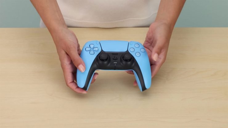 Ein Bild, das eine Person zeigt, die die PlayStation 5 DualSense Startlight Blue hält, ein alternatives Controller-Design für die PlayStation 5