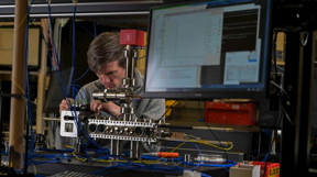 Jonathan Kwolek, Ph.D., a research physicist from the U.S. Naval Research Laboratory (NRL) Quantum Optics Section attaches fiber-optic cables to deliver light into the compact laser-delivery system, which is carefully aligned around a custom vacuum cell in the NRL Atom Interferometry Lab, Nov. 2, 2023. The apparatus will generate a cold, continuous atomic beam which will be delivered into the larger vacuum chamber to address Navy craft inertial navigation challenges. (U.S. Navy photo by Jonathan Steffen)

CREDIT
(U.S. Navy photo by Jonathan Steffen)