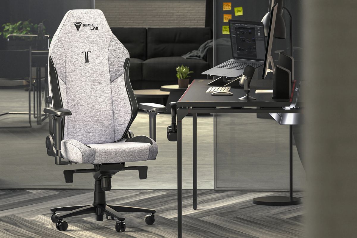 The Secretlab Titan Evo gaming chair is shown in a production office scenario. This chair is covered in a grey fabric.