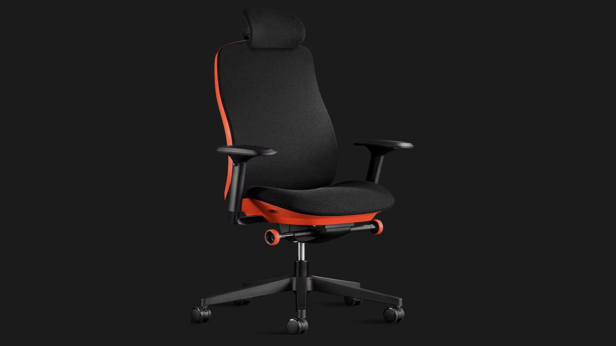 Herman Miller X Logitech Vantum G 人体工学游戏椅显示在黑色背景上。该型号采用黑色面料、黑色扶手和黑色车轮硬件。然而，其座椅和靠背的装饰是红色的。