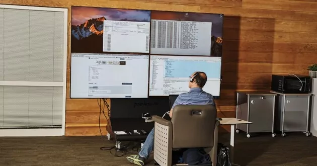 Developer looks at many monitors