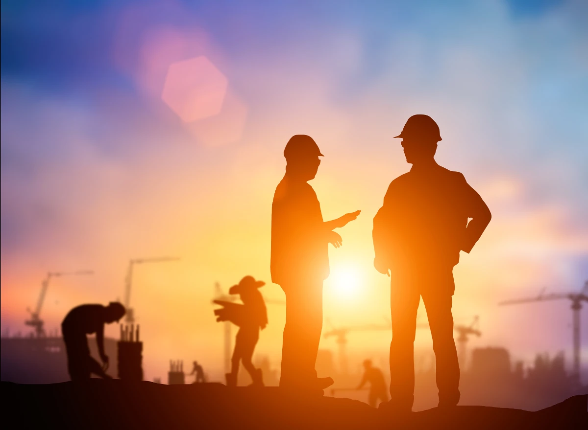 Construction workers with sunrise in background