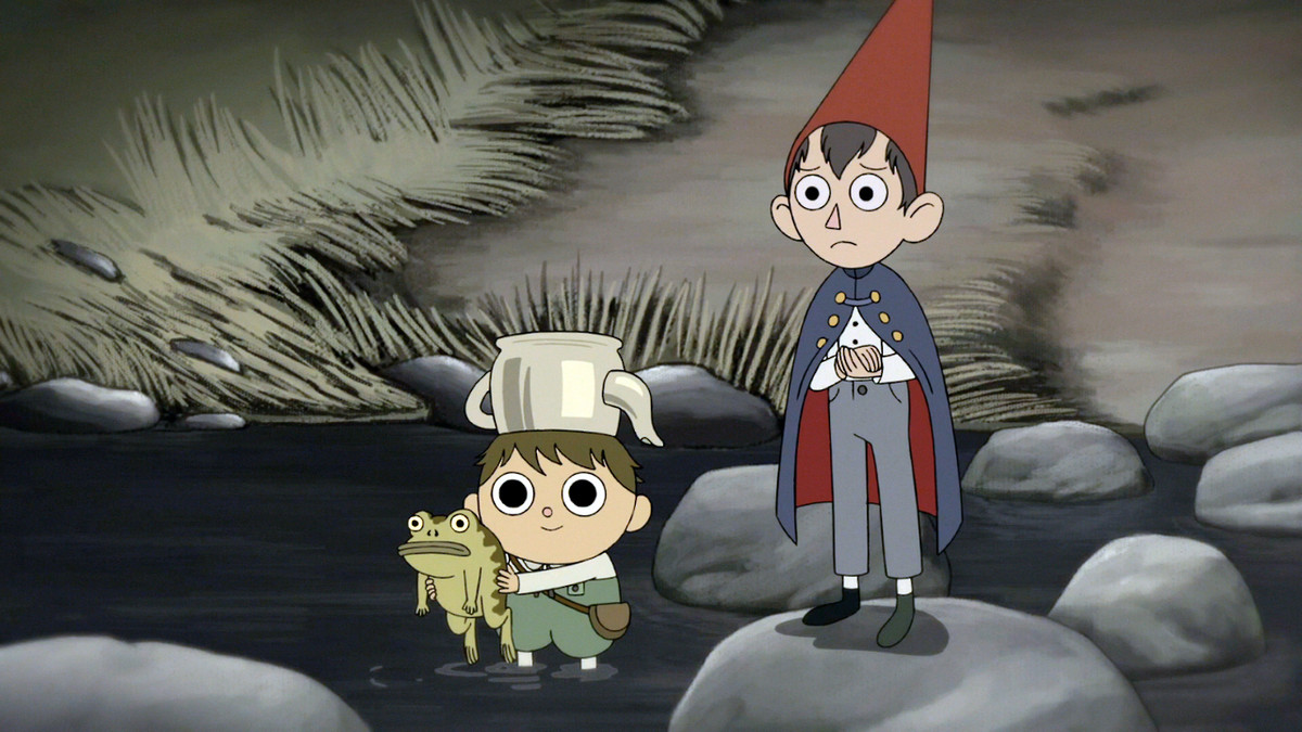 A boy holding a frog with an upside down tea kettle on his head (Greg) and an older boy wearing a red pointed hat and a navy blue cape stand in a river in Over the Garden Wall.